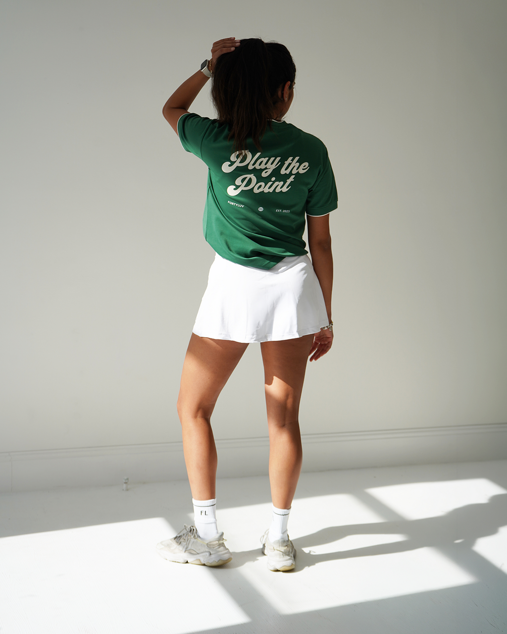 Woman Wearing Padel Green t-shirt with 'Play the Point' text on the back